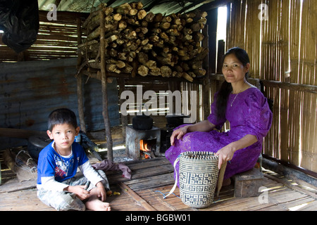 A Penan mother and son in their home, a tiny shack built of wood and bamboo and scrap material in Borneo in Malaysia. Stock Photo