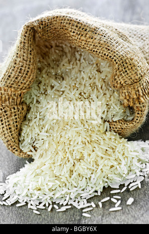 Raw long grain white rice grains in burlap bag Stock Photo