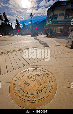 Decorative plaque in the footpath at the corner of Banff Avenue and Wolf Street in downtown Banff, Banff National Park, Canadian Stock Photo