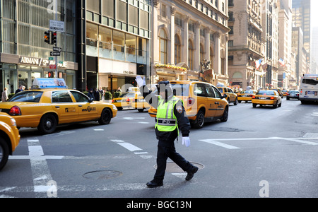 NYPD officer at work directing traffic Midtown Manhattan New York USA Stock Photo