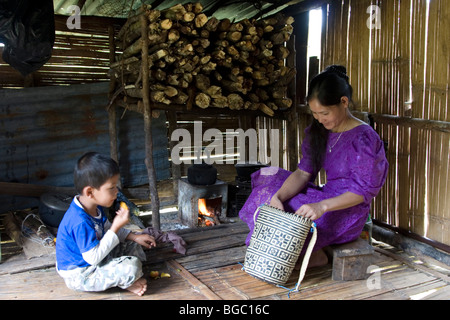 A Penan mother and son in their home, a tiny shack built of wood and bamboo and scrap material in Borneo in Malaysia. Stock Photo