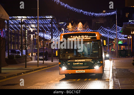 Public transport bus at night in city centre with Christmas decorations Cardiff Wales UK Stock Photo