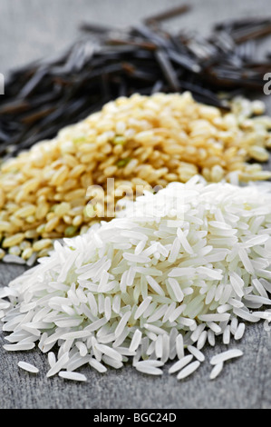 Three piles of white, brown and wild black uncooked rice Stock Photo