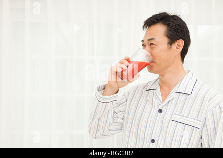 Mature man drinking vegetable juice Stock Photo