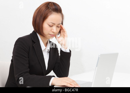 Young businesswoman suffering from headache Stock Photo