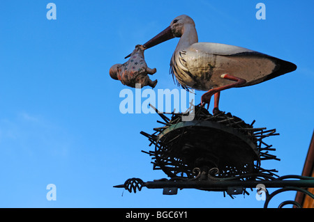 Stork with baby figure in its beak, a children's shop, Obere Bruecke, Bamberg, Upper Franconia, Bavaria, Germany, Europe Stock Photo