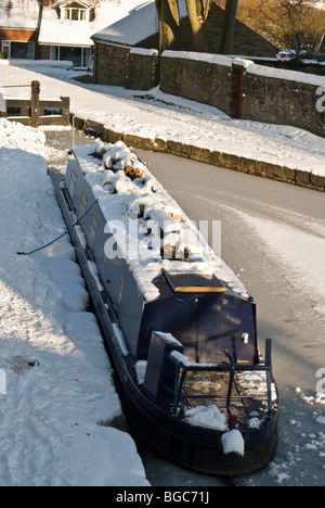 narrow boat at intersection of peak forest and macclesfield frozen canal top lock marple Stock Photo
