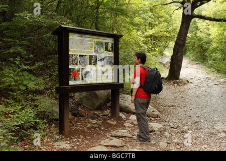 Woman with a backpack in front of an information panel, Velika Paklenica Canyon, Paklenica National Park, Velebit Mountains, Da Stock Photo