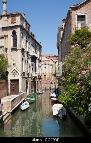 A Venice canal with boats showing traditional Venetian homes by the canal. Stock Photo