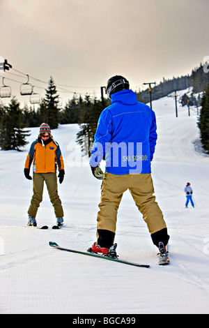 Ski instructor with a student on the beginners slope of Whistler Mountain, Whistler Blackcomb, Whistler, British Columbia, Canad Stock Photo