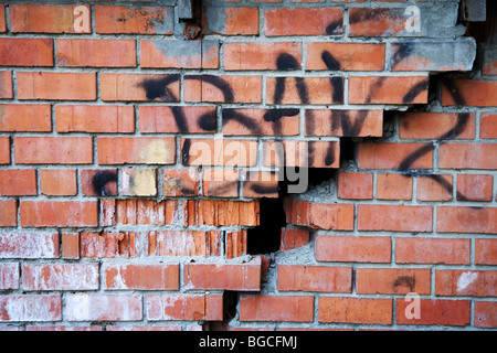 Big crack in the red brick wall. Stock Photo