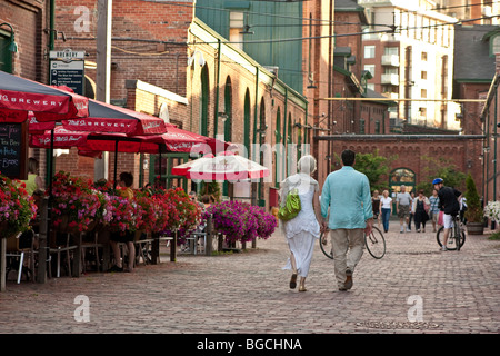 Mature couple holding hands as they walk in the historic Distillery District, Toronto, Canada Stock Photo