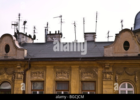 Incongruous mess of TV Aerials and Satellite Dishes on the roofs of ornately decorated buildings in the Wawel district of Krakow Stock Photo