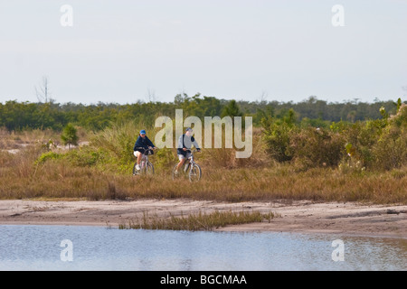People riding bikes in the 400 acre Robinson Preserve in Manatee County in Bradenton Florida Stock Photo