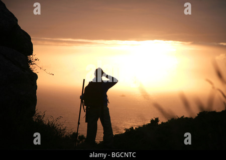 Sunset and girl at Finisterre cape, Camino de Santiago Stock Photo