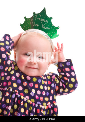 1 year old little girl tries Happy New Year paper crown isolated on white Stock Photo