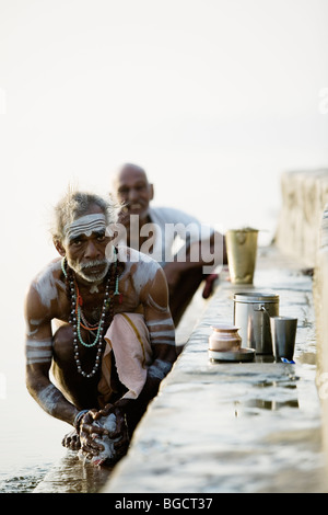 Saddhu, a holy man or beggar monk, washing at holy Ganges River in Varanasi. Stock Photo