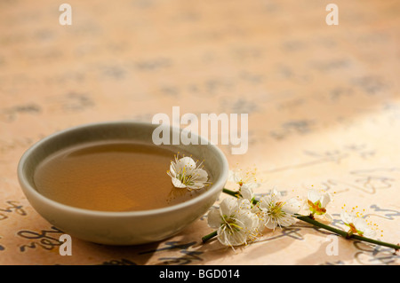 Close-up of a cup of tea and flowers on calligraphy Stock Photo