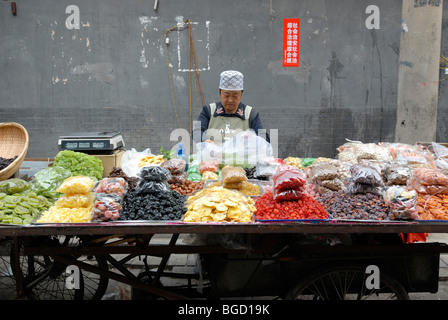 Muslims, Muslim Chinese woman selling candied dried fruit in the Muslim quarter of Xian, Shaanxi, China, Asia Stock Photo