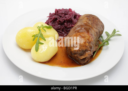 Stuffed beef roulade with gravy, red cabbage and boiled potatoes Stock Photo