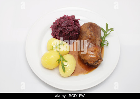 Stuffed beef roulade with gravy, red cabbage and boiled potatoes Stock Photo