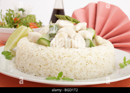 Chicken fricassee with mushrooms and green asparagus surrounded by a rice border, mixed salad Stock Photo