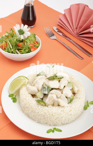 Chicken fricassee with mushrooms and green asparagus surrounded by a rice border, mixed salad Stock Photo