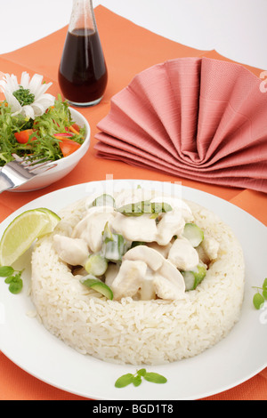 Chicken fricassee with mushrooms and green asparagus surrounded by a rice border, mixed salad Stock Photo