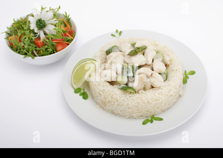 Chicken fricassee with mushrooms and green asparagus surrounded by a rice border, mixed salad Stock Photo