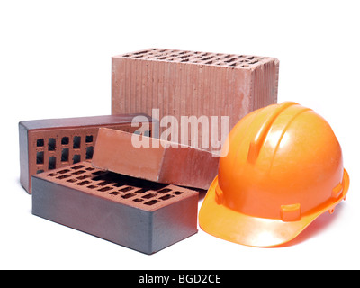 Solid and perforated bricks and orange hard hat isolated on white Stock Photo