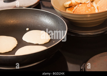 Frying flapjacks in a pan. Crumpets on stove. color. Stock Photo