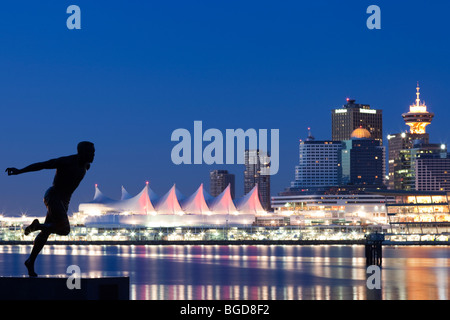 Statue of BC Athlete of the Century Harry Winston Jerome at Stanley Park with Vancouver night skyline and Canada Place Stock Photo
