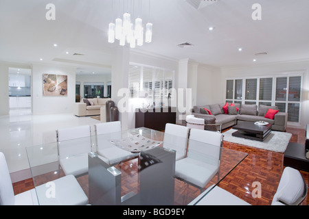 Luxurious dining room with living rooms and kitchen in the background Stock Photo