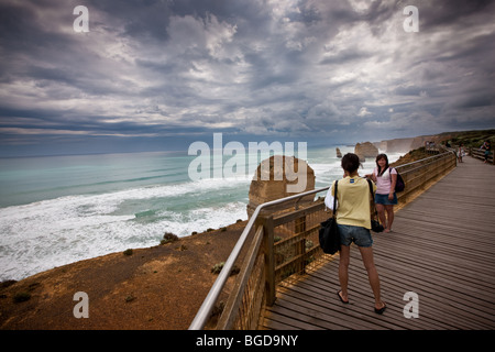 Young tourists photographing each other on board walk at the Twelve Apostles. South West Victoria, Australia. Stock Photo