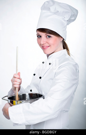 Young chef with wooden spoon and cooking pot Stock Photo