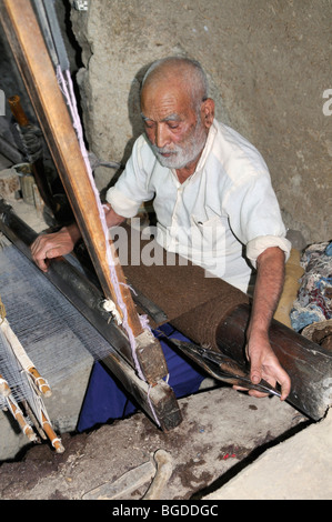 Old Iranian man weaving in his underground shop, Nain, Isfahan, Esfahan, Iran, Persia, Asia Stock Photo