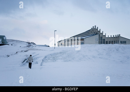 Person walking towards Vidistadakirkja church during winter. Hafnarfjordur, Greater Reykjavik Area, Iceland. Stock Photo