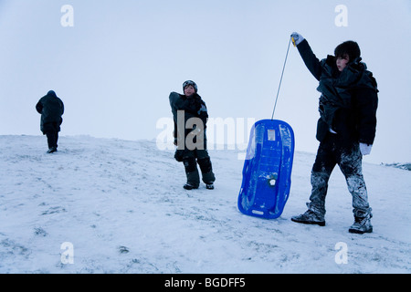 Three boys playing in snow. Hafnarfjordur, Greater Reykjavik Area, Iceland. Stock Photo