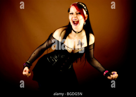 Woman, dressed in a Gothic style, screaming with fists clenched Stock Photo