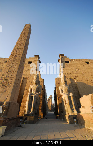 LUXOR, EGYPT. The obelisk, pylon and Colossi of Ramses II at Luxor Temple in the early-morning sun. Stock Photo