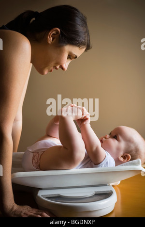 Mother weighing baby Stock Photo