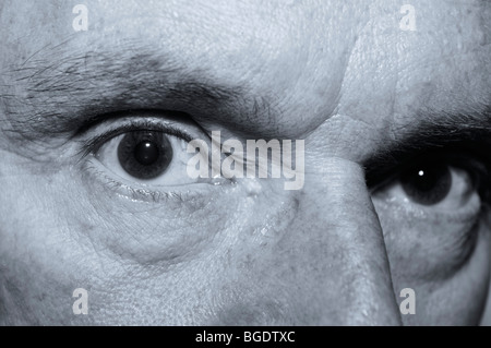 Sinister looking close up of an old mans eyes in monochrome Stock Photo
