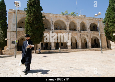 Hassidic Jew walking home with Sabbath groceries through Batei Mahase Square in the Jewish Quarter of the Old City of Jerusalem Stock Photo