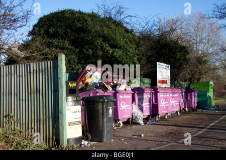 Overflowing recycling bins filled with the wrong rubbish.  Bins marked mixed glass only are filled with cardboard Stock Photo