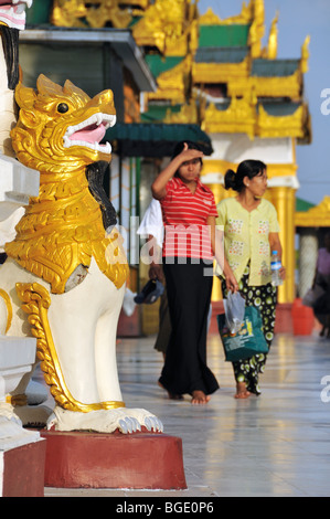 Lion Statue (Chinte) in front of Visitors of the Shwedagon Pagoda, Yangon, Burma, Myanmar Stock Photo