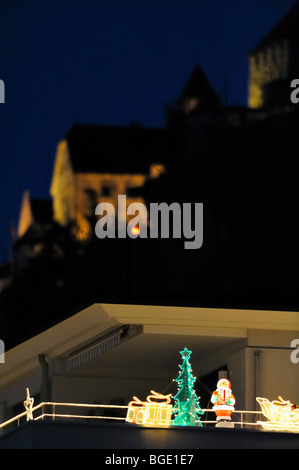 Santa Claus Sledge with two Reindeer and a green Christmas Tree decoration in front of the princely castle at nightfall, Vaduz LI Stock Photo