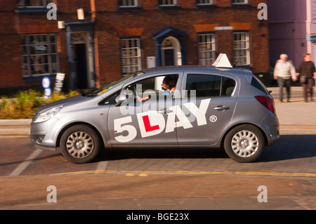 A 5 day learner driver in a driving school car speeds past showing movement in Norwich,Norfolk,Uk Stock Photo