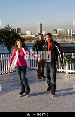 Multi-ethnic group of friends ice skating on a synthetic ice rink aboard the Queen Mary Hotel and Attraction in Long Beach, CA Stock Photo