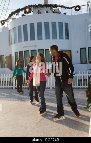 Friends ice skating on a synthetic ice rink aboard the Queen Mary in Long Beach, CA, USA Stock Photo
