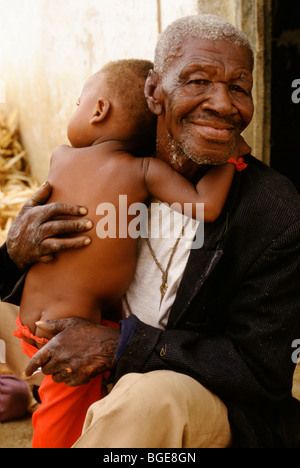 A resident in a leper colony, Luanda, Angola, holds his young son Stock Photo